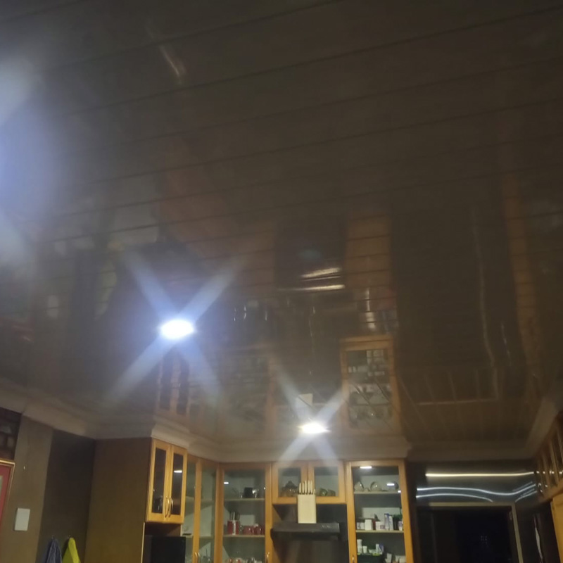 PVC ceiling reflection in a kitchen with wooden cabinetry