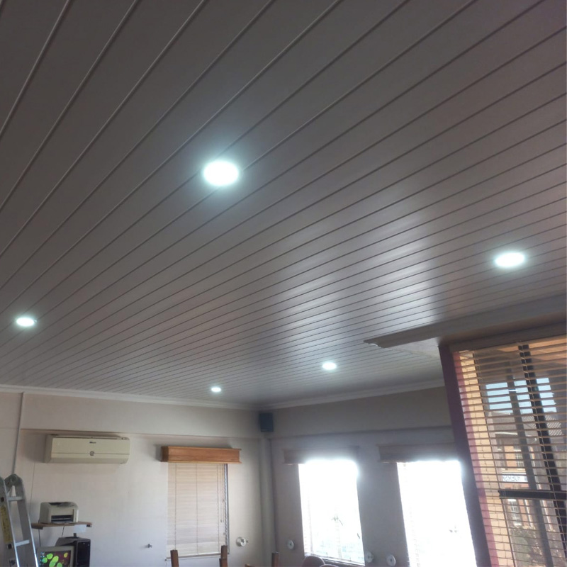Completed PVC ceiling installation with recessed downlights and window blinds